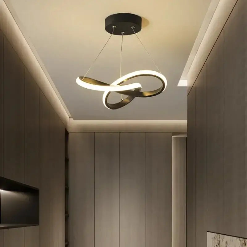Modern black and gold infinity loop pendant light with sleek minimalist design helps create elegant dining room ambiance