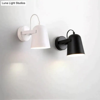 Modern white matte adjustable ferrell wall lamp with cylindrical shades and sleek black and white finishes for bedroom use