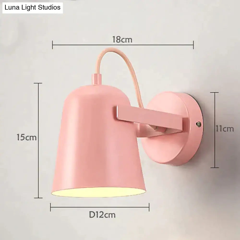 Pastel pink conical ferrell wall lamp with matte finish and curved arm for modern bedroom spotlight use