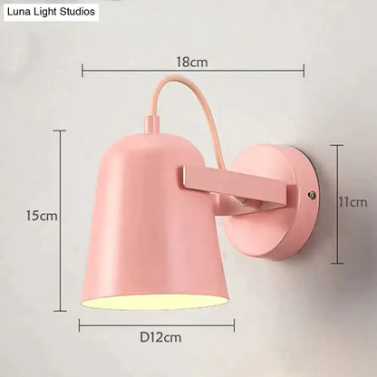 Pastel pink conical matte ferrell wall lamp with curved arm designed as a modern adjustable bedroom spotlight