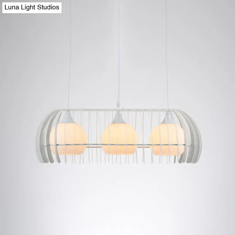 Modern white metal pendant light with three warm glass globe bulbs in cage frame for dining room island light fixture