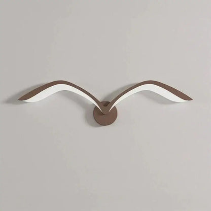Modern nordic avian style wall lamp with white and brown acrylic wings on a bronze circular indoor wall sconce