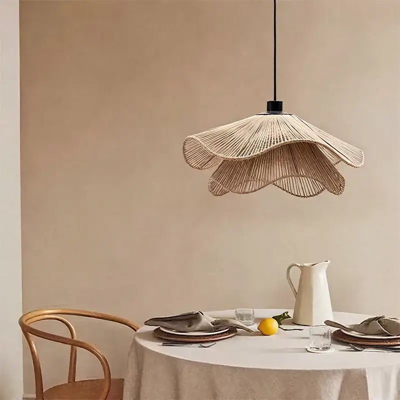 Beige woven rattan pendant light with black cord and fixture complementing modern white petal fabric pendant light