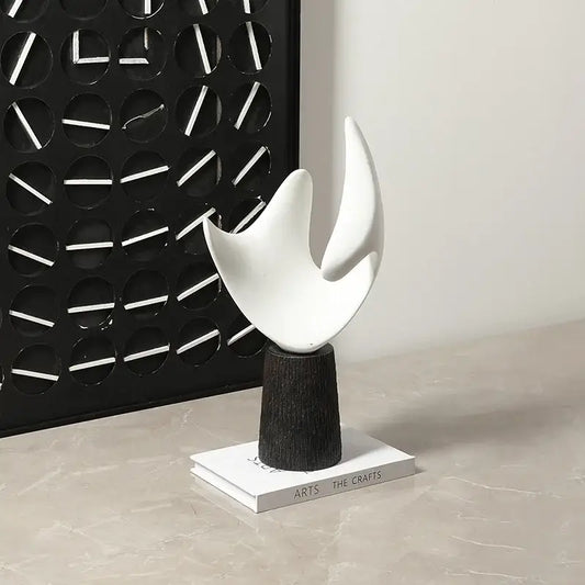 Modern white resin sculpture with smooth flame-like curves on dark wood pedestal for decorbites abstract living room decorbites abstract hollowed-out style