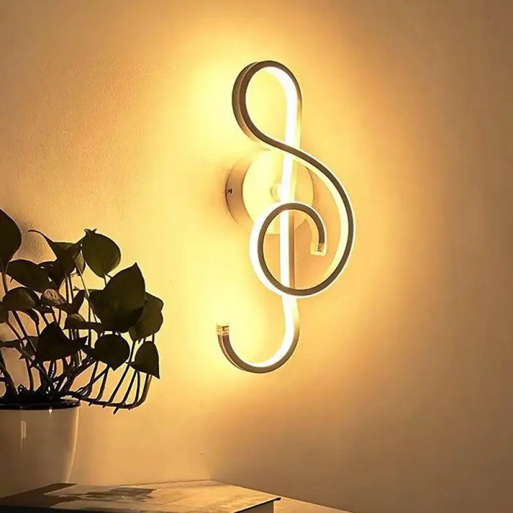 A modern white treble clef led wall sconce featuring an illuminated design for bedroom lighting use