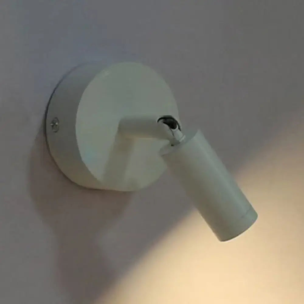 Modern white tube wall light with adjustable arm and cylindrical head ideal as a white light bedroom sconce