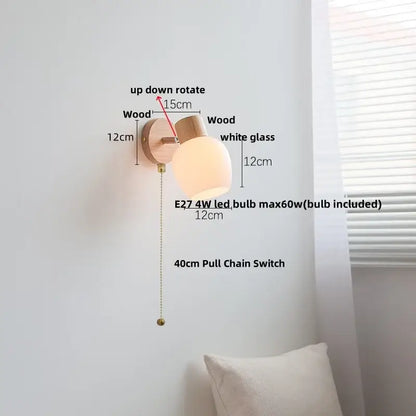 Minimalist wall sconce with light wood finish, white amber glass led shade, and brass pull chain switch by decorbites