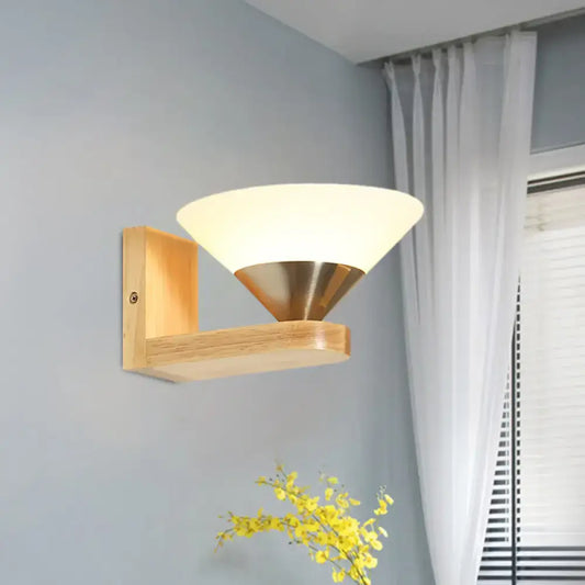 Modern wall lamp with light wood frame frosted glass shade and brass cone for bedroom use mounted on wall