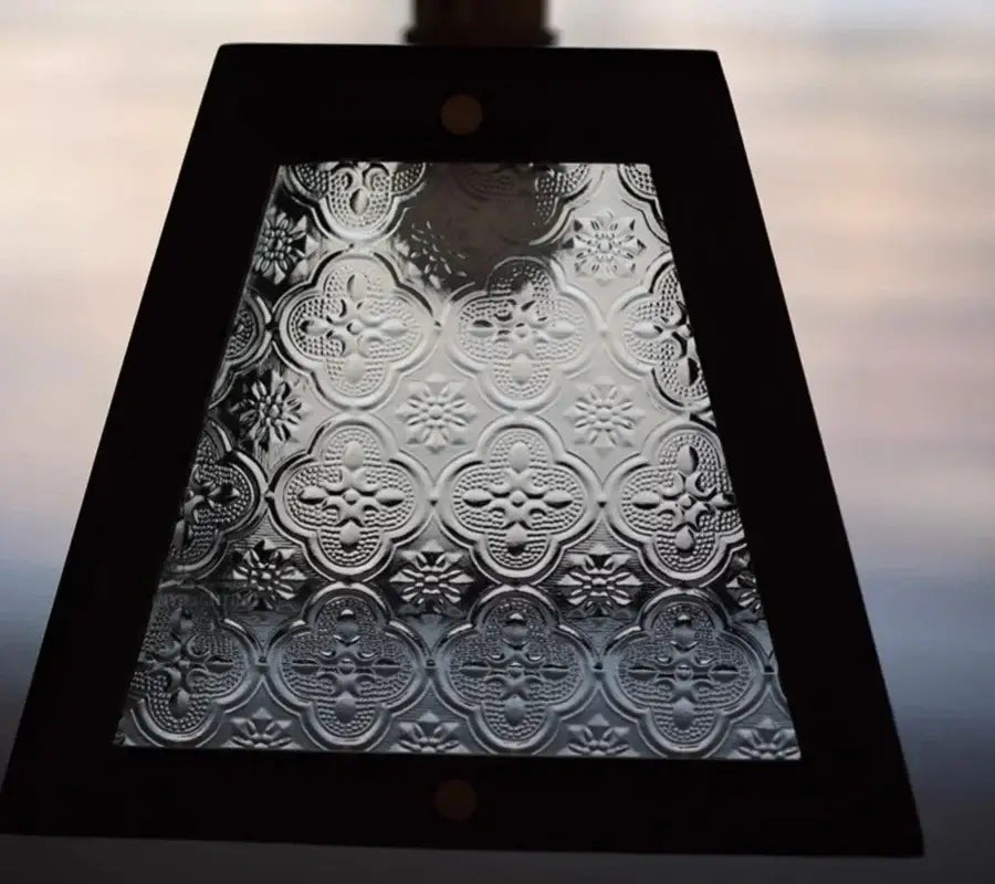 A rectangular black framed modern wood and green led glass pendant lamp with embossed clear quatrefoil glass panel