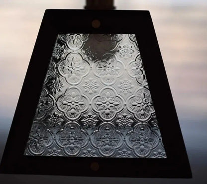 A rectangular black framed modern wood and green led glass pendant lamp with embossed clear quatrefoil glass panel