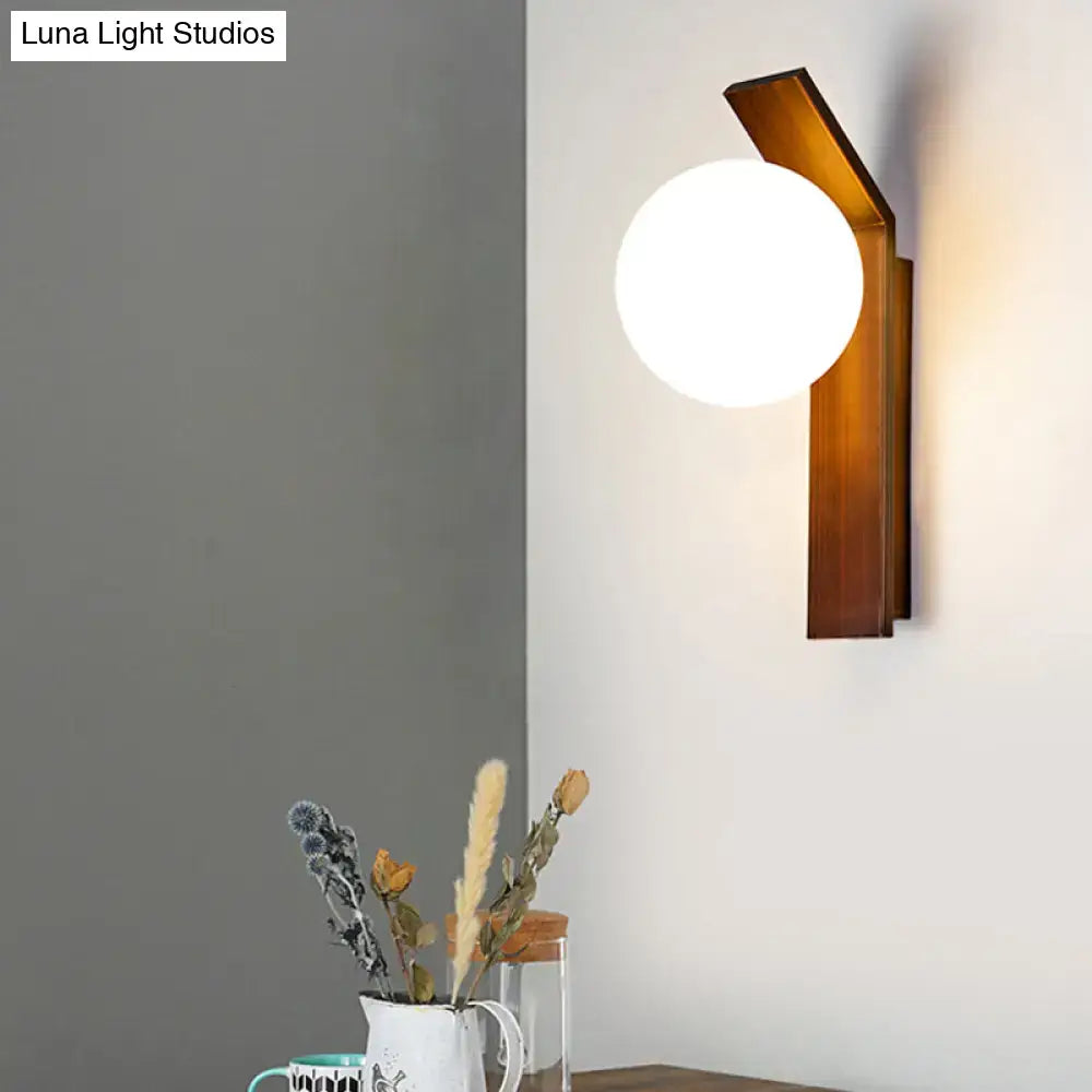 Modern wood and milk glass shade wall sconce with warm wooden frame and frosted milk glass globe for dining room
