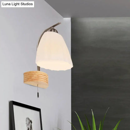 A modern wall lamp with a ribbed glass flared sconce, off-white shade, and woven natural wood base for bedroom lighting
