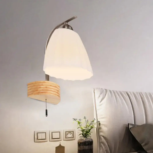 Modern wall lamp with ribbed glass flared shade, brushed metal arm, and wooden pull-chain switch for bedroom lighting