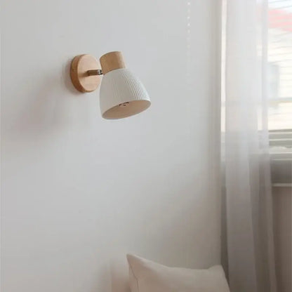 Minimalist wall light fixture with natural wood base and white ribbed ceramic shade for modern bedroom use