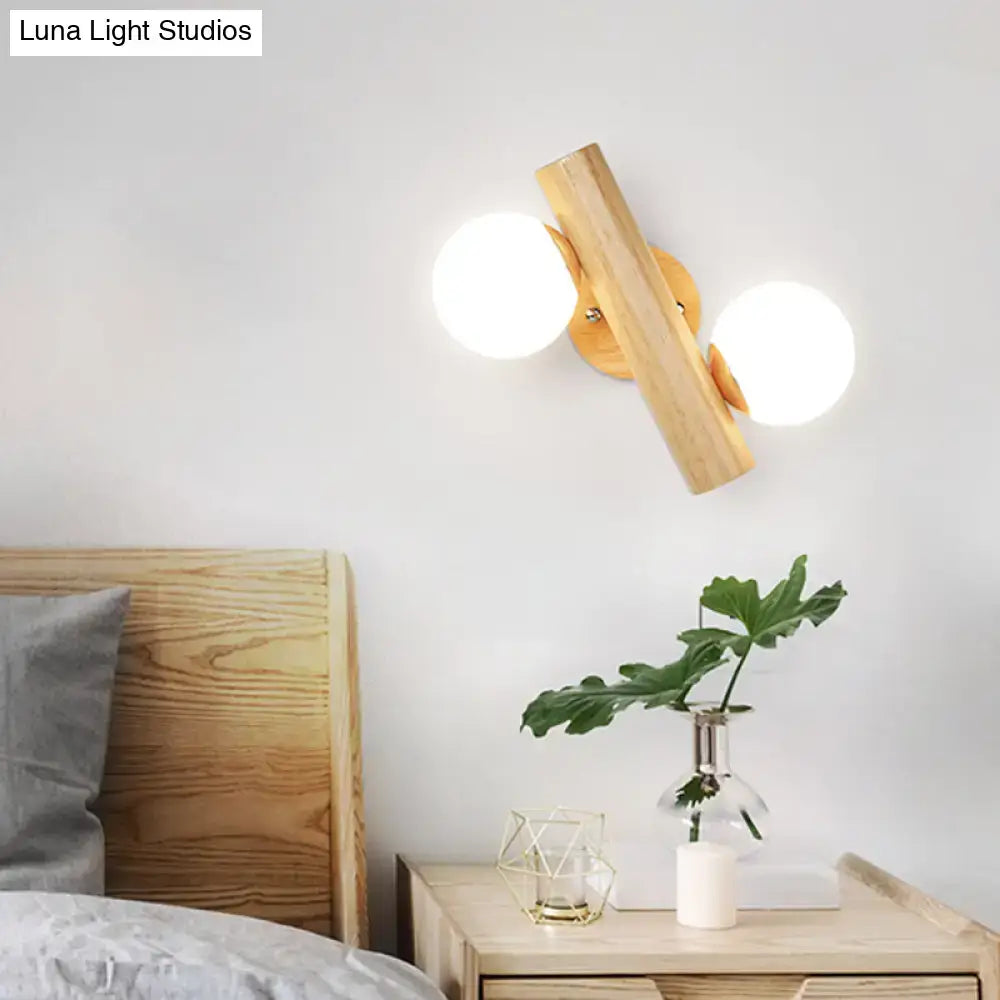 Modern wooden wall sconce with two frosted white glass ball shades for rotating bedroom lighting fixture