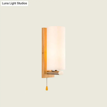 Modern wood and white glass wall sconce with pull chain light featuring warm wooden backplate and frosted glass shade