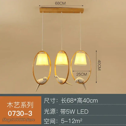 Modern wood bird glass pendant light with gold oval frames, white ceramic birds, and warm led lighting for kitchen decorbites bird glass pendant