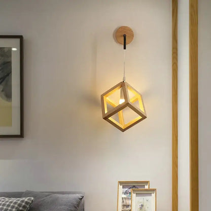 A warm-toned wooden cube led wall light with minimalist design suspended from a circular wood base for bedroom use