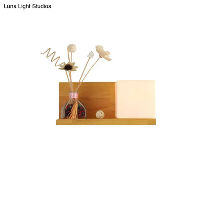 Modern wood floating shelf with beige wall lamp and sconce light holding glass diffuser and dried flower reeds