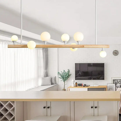 Modern wood island lamp with five frosted glass globe bulbs on a slender wooden bar for dining room use