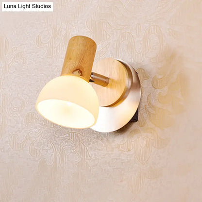Modern wood sconce with warm-toned wooden base and milk white glass shade for bedroom wall lighting