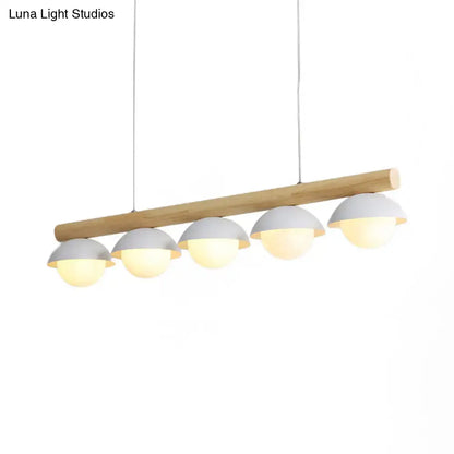 Modern pendant linear chandelier with natural wood stem and five matte gray dome white shades emitting warm light