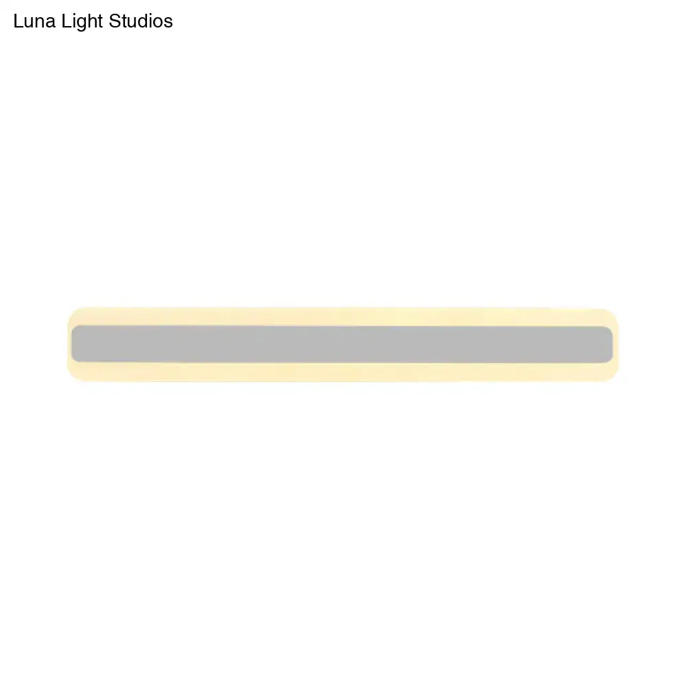 A sleek minimalist bathroom vanity light strip with matte gray center and cream rounded edges emitting white light