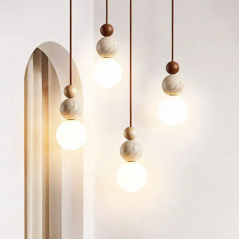 Modern yellow travertine and wood led bulb pendant light with spherical concrete and wood beads suspended by thin cords
