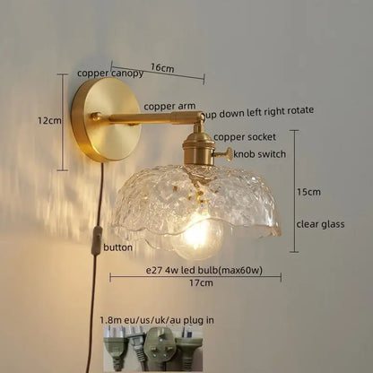 A vintage-style wall lamp with brass-finished copper arm and ornate clear glass led shade with bubble texture