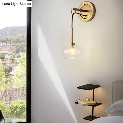 Gold-toned modernist amber white glass wall sconce with clear globe and black cord for bedroom drop lamp lighting