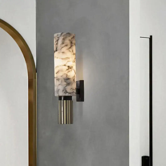 A modernist black and marble coffee house wall sconce with a cylindrical marble glass shade and dark metal base