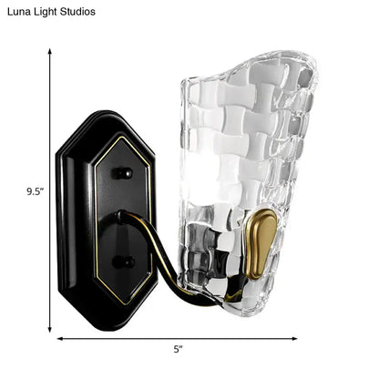 Modernist black and gold wall sconce with clear crystal panel and woven textured glass for bedroom lighting