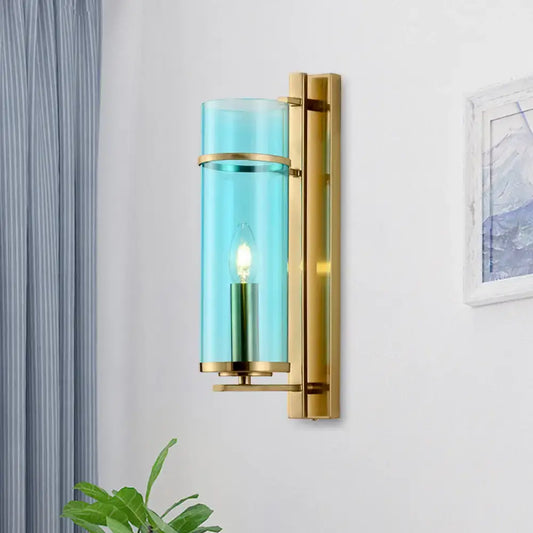 A modernist bedroom sconce light featuring a sleek wall lamp with water blue glass and polished brass hardware