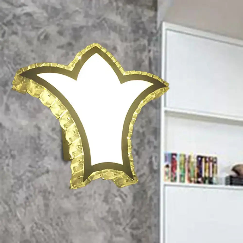 Modernist gold crown wall light with clear k9 crystal textured border and bright white illuminated center for bedroom use