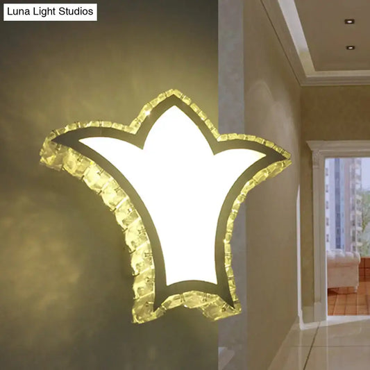 Modernist gold crown wall light with clear k9 crystal border and bright white illuminated star-shaped center for bedroom