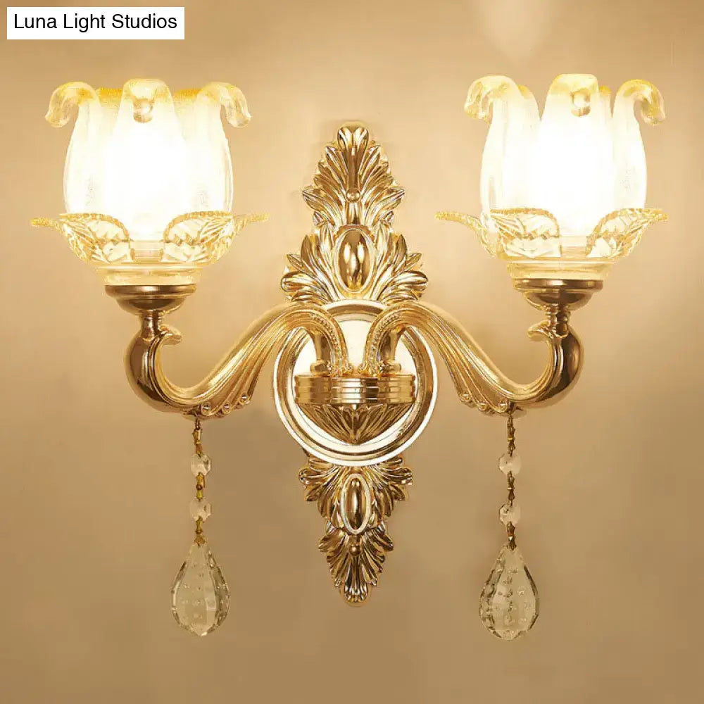 Modernist gold wall sconce with direct wired electric, glass shade, and dangling crystal teardrop pendants