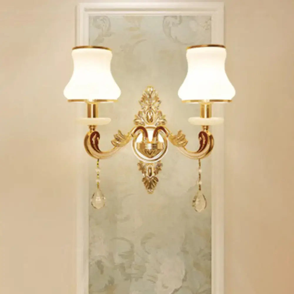 Modernist gold wall sconce with two white frosted glass shades and direct wired electric installation for living rooms