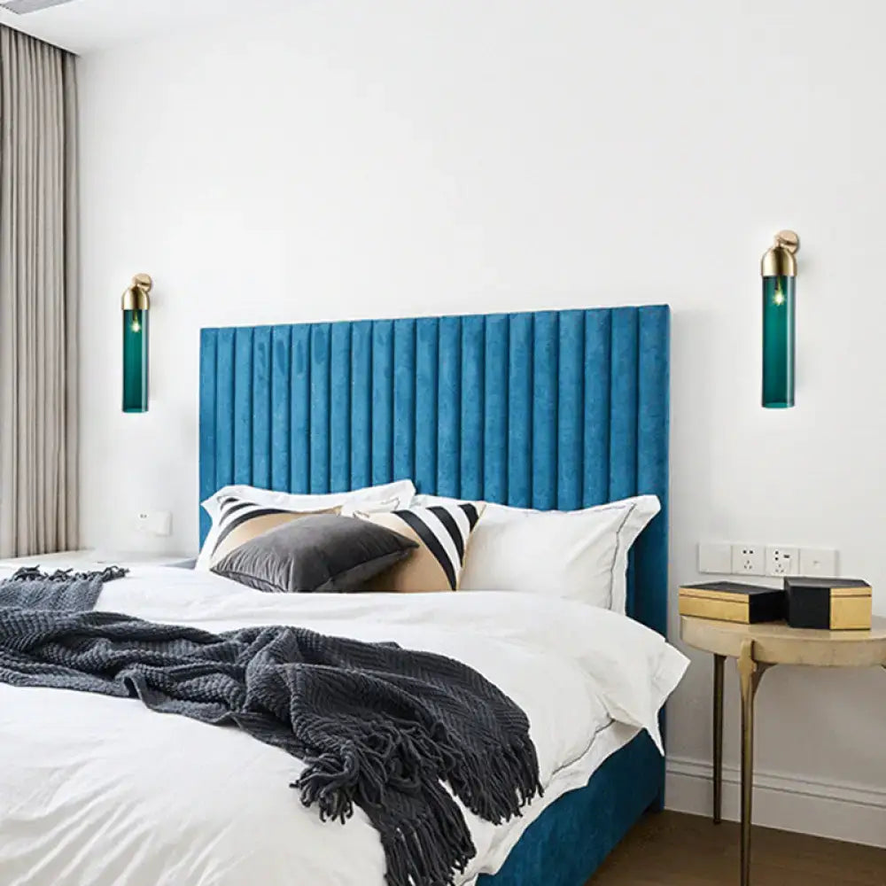 Blue tufted velvet headboard paired with modernist metallic tube sconce light featuring a curved arm for bedroom use