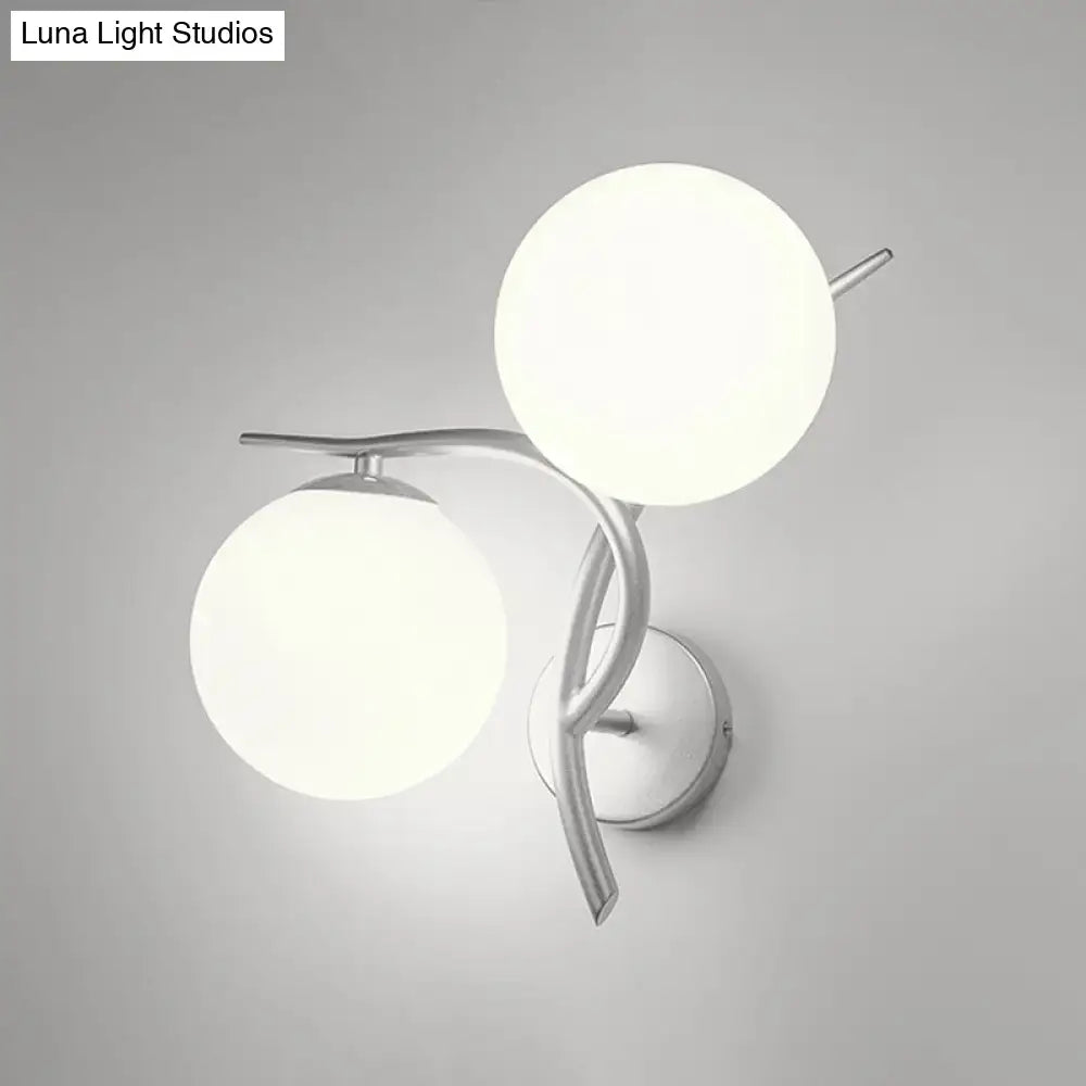 Modern two-light wall sconce with sleek silver black arms and milky glass shades for bedroom light fixture