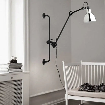 Modernist style black wall light with articulated arm and polished chrome shade for dining room lighting