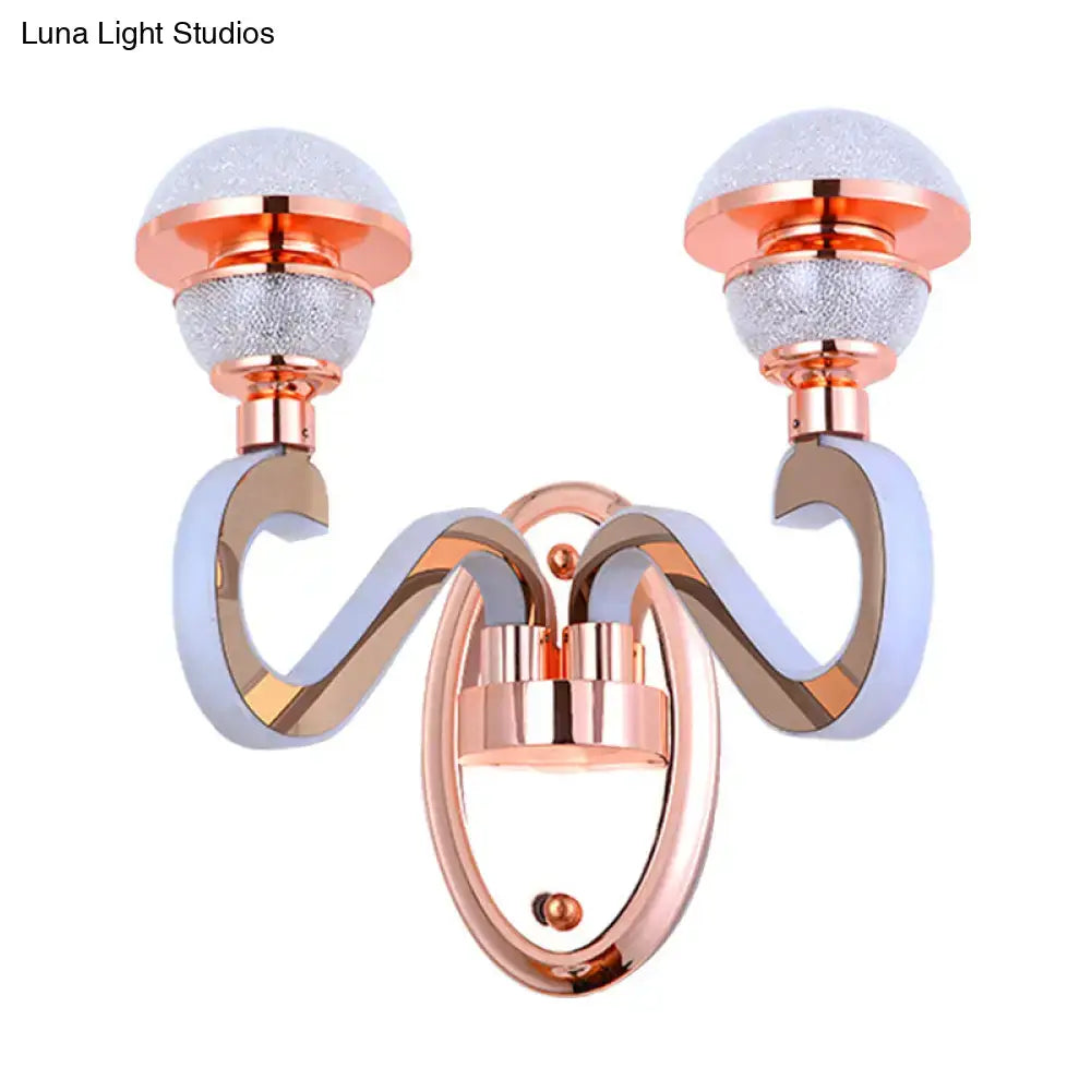 Modernist urn shape rose gold wall sconce with two frosted glass globe shades and curved metallic arms for bedroom lighting