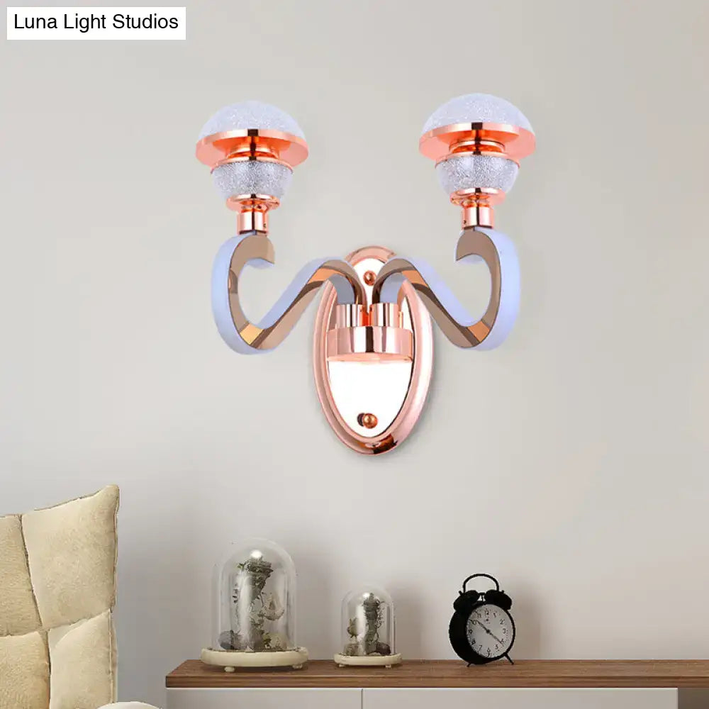 Modernist urn shape rose gold wall sconce with two frosted glass globe shades and curved metallic arms for bedroom lighting
