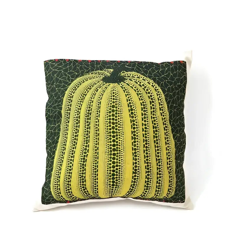 A vibrant yellow decorbites cotton pumpkin pillowcase with dotted texture and black stem on dark green cushion decor