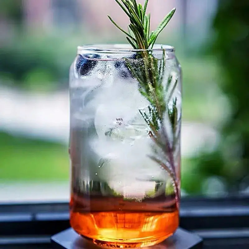 Motivational engraved clear glass beer glass cup filled with ice blueberries rosemary and amber liquid at the bottom