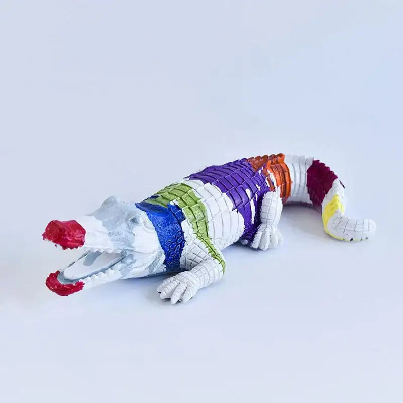 Multicolor striped crocodile wildlife sculpture with vibrant purple green blue orange red yellow stripes on white base decorbites crocodile wildlife decor