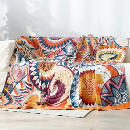 A multicolored cotton gauze boho throw blanket with bold geometric and spiral patterns for bedroom or living room decorbites cotton gauze