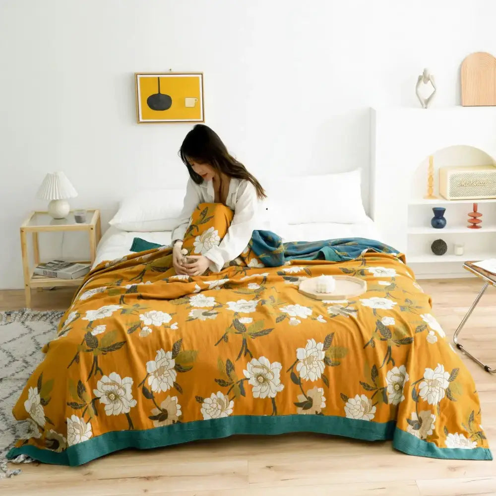 Warm orange floral decorbites cotton gauze boho throw blanket with white blossoms and teal border for living room