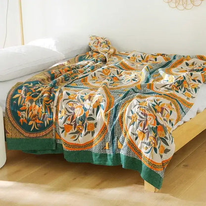 A multicolored cotton gauze boho throw blanket with vibrant orange green floral motifs and geometric borders for decorbites