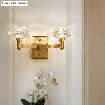 Gold-toned mussel brass wall mounted lamp with two faceted crystal shades for bedroom or doorway wall lamp use