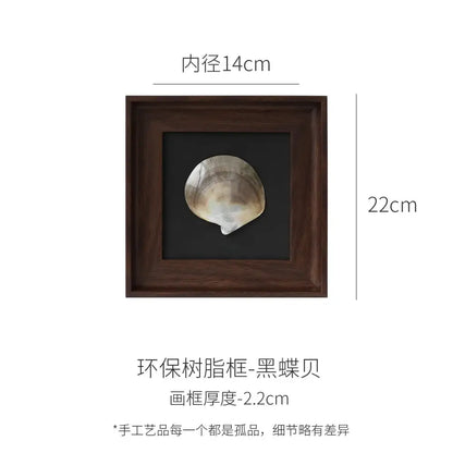 A dark brown wooden decorative painting frame with a natural black abalone shell on a matte black background